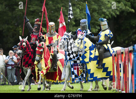 I Cavalieri a cavallo prendono parte a un torneo di giostre medievale annuale per essere incoronati campione al Palazzo di Linlithgow, Linlithgow, West Lothian, Scozia. Foto Stock