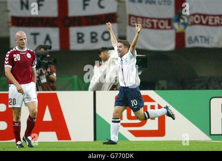 Michael Owen celebra il secondo gol dell'Inghilterra mentre Kasper Bogelund, Danimarca, guarda durante la seconda partita della Coppa del mondo tra Inghilterra e Danimarca al Big Swan Stadium di Niigata, Giappone, sabato 15 giugno 2002. L'Inghilterra ha sconfitto la Danimarca 3-0 per raggiungere i quarti di finale della Coppa del mondo. Foto Stock