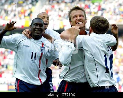 Michael Owen si congratula con i compagni di squadra David Beckham, Emile Heskey (r) e Rio Ferdinand dopo aver segnato l'apripista durante la quarta finale della Coppa del mondo all'Ecopa Stadium di Shizuoka, Giappone. Foto Stock