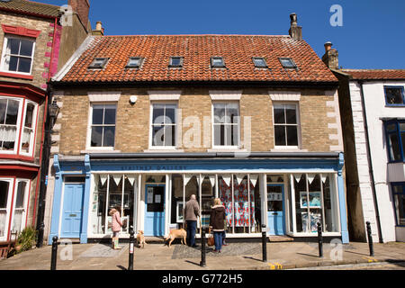 Regno Unito, Inghilterra, Yorkshire, Staithes, High Street, i clienti che cercano in Staithes galleria finestra Foto Stock