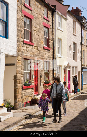 Regno Unito, Inghilterra, Yorkshire, Staithes, High Street, famiglia camminando sulla pavimentazione Foto Stock