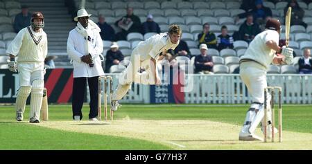 Il capitano del Surrey Adam Hollioake (a sinistra) guarda il lanciatore del Lancashire James Anderson in azione, durante la partita del campionato della contea di Frizzell all'Oval. Foto Stock