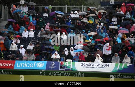 Folle sotto la pioggia al Kelvingrove Lawn Bowls Center, durante i Giochi del Commonwealth 2014 a Glasgow. Foto Stock