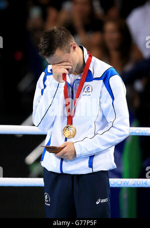 Josh Taylor della Scozia celebra con la sua medaglia d'oro dopo la vittoria nella finale maschile del Welter leggero (64kg) alla SSE Hydro, durante i Giochi del Commonwealth 2014 a Glasgow. Foto Stock