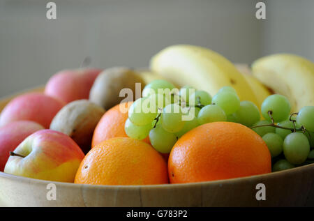 Uva, arance, mele, banane e kiwi in un recipiente di frutta. Foto Stock