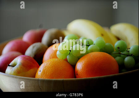 Uva, arance, mele, banane e kiwi in un recipiente di frutta. Foto Stock