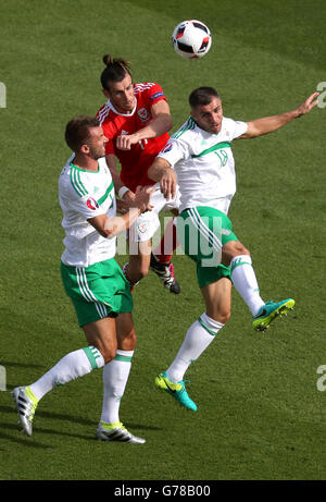 Il Galles Gareth Bale (centro) battaglie per la sfera contro Irlanda del Nord la Aaron Hughes (a destra) e in Irlanda del Nord la Gareth McAuley durante il round di 16 corrispondono al Parc de Princes, Parigi. Foto Stock