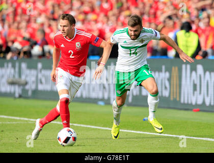 Il Galles Chris Gunter (sinistra) e in Irlanda del Nord la Stuart Dallas battaglia per la sfera durante il round di 16 corrispondono al Parc de Princes, Parigi. Foto Stock