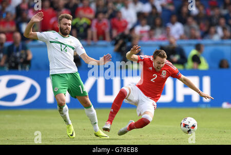 In Irlanda del Nord la Stuart Dallas (sinistra) e il Galles Chris Gunter battaglia per la sfera durante il round di 16 corrispondono al Parc de Princes, Parigi. Foto Stock