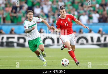 In Irlanda del Nord la Oliver Norwood (sinistra) e il Galles Gareth Bale battaglia per la sfera durante il round di 16 corrispondono al Parc de Princes, Parigi. Foto Stock