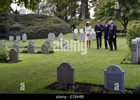 Il Duca di Cambridge e la Duchessa di Cambridge camminano e parlano con il primo Ministro David Cameron e una persona non identificata durante una visita al Cimitero militare di St. Symphorien a Mons, Belgio, mentre presenziano ad una cerimonia per commemorare il centesimo anniversario dello scoppio della prima guerra mondiale. Foto Stock