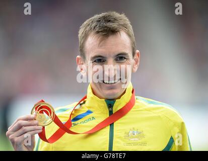 Michael Shelley in Australia festeggia con la sua medaglia d'oro dopo aver vinto la Maratona maschile, a Hampden Park, durante i Giochi del Commonwealth 2014 a Glasgow. Foto Stock