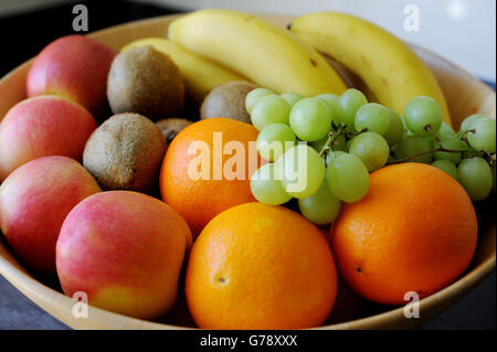 Uva, arance, mele, banane e kiwi in un recipiente di frutta. Foto Stock