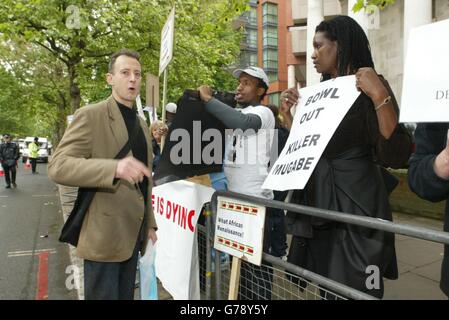 Peter Tatchell (sinistra), attivista per i diritti umani, parla con i manifestanti anti anti di Mugabe prima dell'inizio del primo test tra Inghilterra e Zimbabwe a Lords. Foto Stock