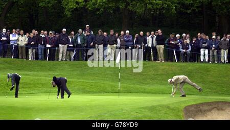 Paul Casey (all'estrema destra), Jose Maria Olazabal (centro) e Ernie Els del Sud Africa, segnano le loro palle sul 2° verde al Volvo PGA Championship al Wentworth Golf Club, Surrey. Foto Stock