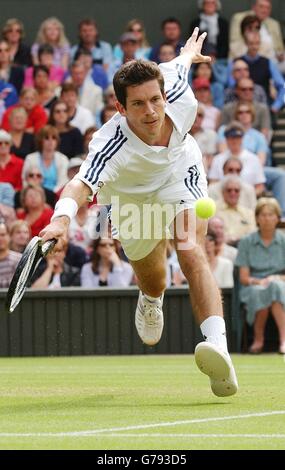 , NESSUN UTILIZZO DEL TELEFONO CELLULARE. Il britannico Tim Henman a pieno titolo durante la sua partita contro Sebastien Grosjean dalla Francia nella finale del quarto maschile all'All England Lawn Tennis Championships a Wimbledon. * la partita è stata ripresa dopo essere stata abbandonata a causa di interruzioni della pioggia e scarsa illuminazione. 30/06/2004: Tim Henman si batte per un posto nella semifinale mercoledì 30 giugno 2004 per la quinta volta nella sua carriera di Wimbledon. Il numero uno britannico affronterà il non vedente Mario Ancic, 20 anni, al Centre Court nel loro scontro finale di quarto. Foto Stock