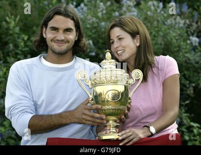 Roger Federer dalla Svizzera e la sua fidanzata Miroslava Vavrinev posano con il trofeo dopo la vittoria su Mark Philippoussis dall'Australia nella finale maschile 7:6/6:2/7:6 al campionato di tennis al prato All England a Wimbledon. Foto Stock