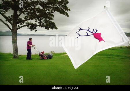 Il Green Keeper Ian Craig taglia l'erba sulla sesta buca del Loch Lomond Golf Club vicino a Balloch in preparazione del campionato scozzese Open Golf che inizia il giovedì. Foto Stock