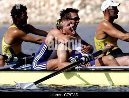 Il vogatore britannico James Cracknell abbracca quattro volte il medalista d'oro olimpico Matthew Pinsent (fronte) dopo che la squadra britannica ha vinto la finale di canottaggio maschile durante i Giochi Olimpici 2004 al Centro di canottaggio olimpico di Schinias ad Atene. Foto Stock