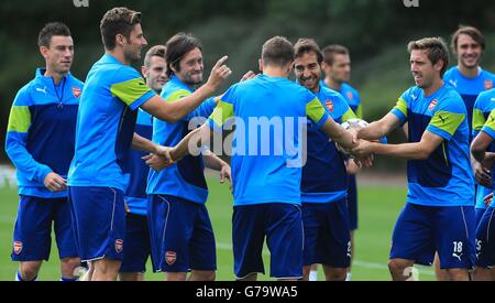 Arsenal's Aaron Ramsey (centro) scherza con Olivier Giroud (seconda a sinistra), Tomas ROSICKY, Mathieu Flamini, e Nacho Monreal (a destra), che tutti flick orecchie Ramsey durante una sessione di allenamento a London Colney, Hertfordshire. Foto Stock