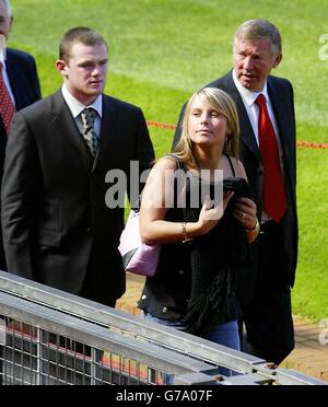 Il New Manchester United firma Wayne Rooney con la ragazza Coleen e il manager Sir Alex Ferguson ad una conferenza stampa presso l'Old Trafford Ground di Manchester United. Il 18-year-old England attaccante ha completato il suo trasferimento a United da Everton in un affare potenzialmente del valore di 27milioni al Merseyside club poco più di quattro ore prima della chiusura del trasferimento finestra di ieri. Foto Stock