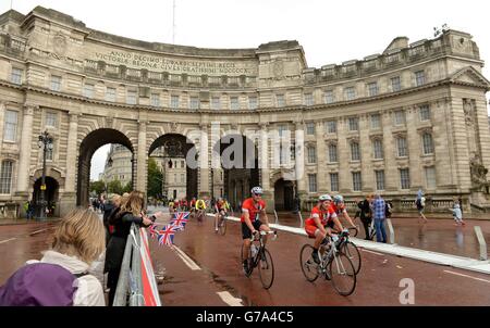 I ciclisti si fanno strada attraverso l'Admiralty Arch on the Mall mentre prendono parte al Prudential RideLondon-Surrey 100 durante il Prudential RideLondon a Londra. Foto Stock