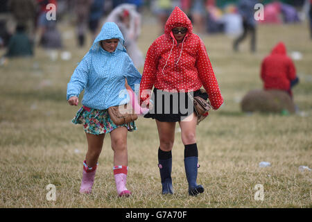 I frequentatori del festival si fanno strada attraverso la pioggia durante il secondo giorno del V Festival al Weston Park a Staffordshire. Foto Stock