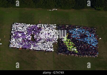 Foto aerea di centinaia di Scout che formano un mosaico umano che mette in evidenza la causa del commercio equo con i paesi più poveri. 1,800 ragazzi e ragazze e i loro leader che hanno formato l'emblema del Fair Trade al Campeggio Downe International vicino a Biggin Hill, a sud-est di Londra. Il mosaico è stato il culmine di uno speciale evento internazionale presso il sito che ha educato gli Scout da tutto il mondo sulle questioni del commercio equo e solidale. Foto Stock