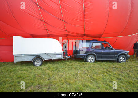 I mongolfiera vengono gonfiati prima di una salita di massa alla 36a edizione della festa internazionale delle mongolfiere presso l'Ashton Court Estate vicino a Bristol, che è il più grande evento di mongolfiera d'Europa. Foto Stock