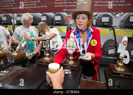 Una bar-woman serve birra ai clienti al Great British Beer Festival (GBBF) di Olympia London, Keningston, Londra, organizzato dalla Campaign for Real Ale (CAMRA). Foto Stock