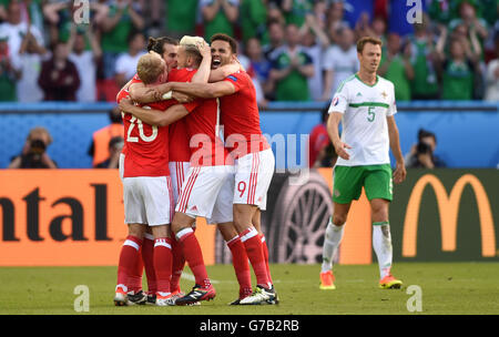 (Da sinistra a destra) il Galles Jonny Williams, Gareth Bale, Aaron Ramsey e Hal Robson-Kanu festeggiare sul passo come in Irlanda del Nord la Jonny Evans passeggiate off sconsolato dopo il turno del 16 corrispondono al Parc de Princes, Parigi. Stampa foto di associazione. Picture Data: Sabato 25 Giugno, 2016. Vedere PA storia SOCCER Wales. Foto di credito dovrebbe leggere: Joe Giddens/filo PA. Restrizioni: Utilizzo soggetto a restrizioni. Solo uso editoriale. Libri e riviste è consentito vendite fornendo non esclusivamente dedicato a qualsiasi team/player/corrispondono. Uso non commerciale. Chiamate il numero +44 (0)1158 447447 per ulteriori informazioni. Foto Stock