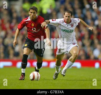 Manchester Uniteds Cristiano Ronaldo (a sinistra) batte con Leonard Naidin di Dinamo Bucharest durante la loro partita di seconda tappa del terzo turno di qualificazione della UEFA Champions League a Old Trafford, Manchester. Foto Stock