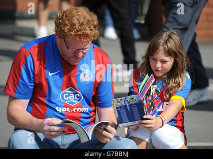 Calcio - Barclays Premier League - Crystal Palace / Burnley - Selhurst Park. I sostenitori di Crystal Palace leggono il programma della partita prima della partita contro Burnley. Foto Stock