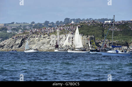 Folle di spettatori si riuniscono per guardare alte navi che prendono parte alla Parata di vela dal porto di Falmouth mentre si dirigono verso il punto di partenza per la corsa a Greenwich, Londra, sotto la vela. Foto Stock