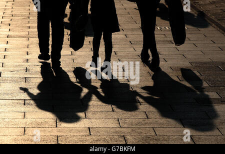 Le ombre sono gettate dalle persone che camminano in Princes Street a Edimburgo, mentre il sole tramonta questa sera. Foto Stock