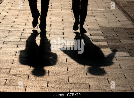 Le ombre sono gettate dalle persone che camminano in Princes Street a Edimburgo, mentre il sole tramonta questa sera. Foto Stock