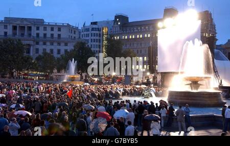 La folla attende sotto la pioggia prima che i PET Shop Boys eseguano un nuovo punteggio per il classico film del 1925 "Battleship Potemkin" con la famosa Dresden Sinfoniker a Trafalgar Sqaure, nel centro di Londra. L'evento è il momento culminante del programma estivo di Trafalgar Square, con oltre 10,000 persone attese. Foto Stock