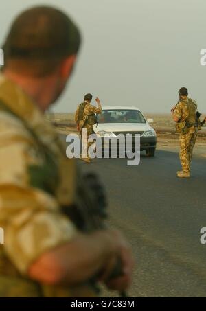 Soldati del 51 Squadron RAF Regiment basato a RAF Lossiemouth in Scozia fermare le auto mentre in pattuglia intorno a Basra e prendere posizione lungo il lato della strada su una prima mattina pattuglia . Lo squadrone è responsabile della protezione dell'aeroporto di Basra dagli attacchi. Foto Stock