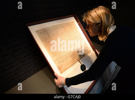 Caroline de Stefani, conservatrice del London Metropolitan Archive, posiziona la Magna carta 1297 durante la sua installazione nella nuova Heritage Gallery, nella città di Londra. Foto Stock