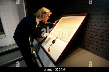 Caroline de Stefani, conservatrice del London Metropolitan Archive, posiziona la Magna carta 1297 durante la sua installazione nella nuova Heritage Gallery, nella città di Londra. Foto Stock