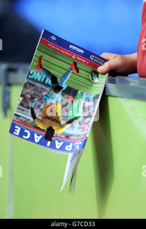 Dettaglio come un giovane fan di Burnley tiene la sua giornata di partita programma in stand prima del gioco Foto Stock
