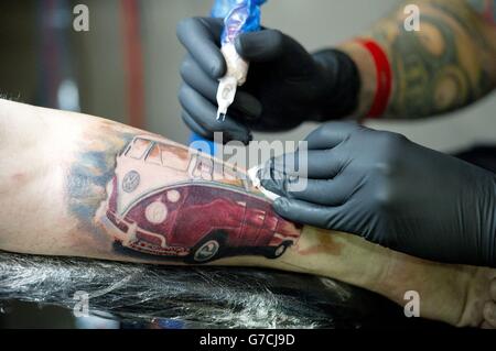 Kieran Brown ottiene un van VW tatuato sul suo braccio al decimo congresso internazionale del tatuaggio di Londra, Londra orientale. Foto Stock