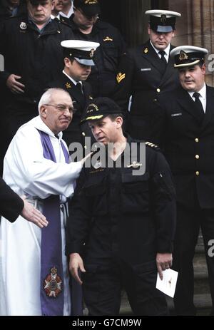 Comander Luc Pelletier (centro) parte dal servizio commemorativo nella chiesa di Rhu, non lontano dalla base navale di HM Clyde a Faslane, vicino a Glasgow, per il tenente Chris Saunders uno dei suoi equipaggio che è morto a bordo del sommergibile Chicoutimi. Foto Stock