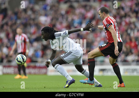 Bafetimbi Gomis di Swansea City (a sinistra) e John o'Shea di Sunderland combattono per la palla durante la partita della Barclays Premier League allo Stadium of Light di Sunderland. Foto Stock