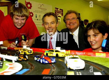 Il primo ministro Tony Blair con il direttore del CBI Digby jones condivide una corsa al scalextrix con gli studenti Stephen Skrzeczkowski (13) e Holy Wadsworth (12) durante una visita alla Heart of England School, Balsall Common. Foto Stock