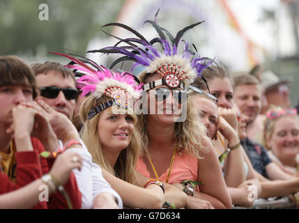 I festaioli che indossano i guarigioni degli Indiani d'America si esibiscono nella folla guardando il 1975 che si esibisce sul palco di Pyramid al Glastonbury Festival, presso la Worthy Farm di Somerset. PREMERE ASSOCIAZIONE foto. Data immagine: Domenica 29 giugno 2014. Il credito fotografico dovrebbe essere: Filo Yui Mok/PA Foto Stock