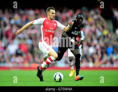 Aaron Ramsey dell'Arsenal combatte per la palla con Mohamed DIAME di Hull City durante la partita della Barclays Premier League all'Emirates Stadium di Londra. Foto Stock