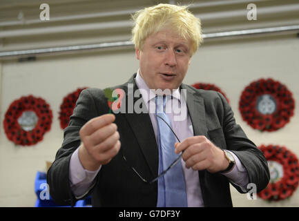 Il Sindaco di Londra, Boris Johnson visita la Poppy Factory a Richmond, a sud-ovest di Londra, dove ha incontrato veterani di guerra e aiutato a fare i papaveri per la Domenica della memoria. Foto Stock