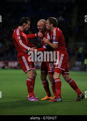 **RACCOLTO ALTERNATIVO** David Cotterill (centro) del Galles celebra il primo gol del gioco con i compagni di squadra Andy King (a destra) e Gareth Bale durante la partita di qualificazione UEFA Euro 2016 al Cardiff City Stadium di Cardiff. Foto Stock