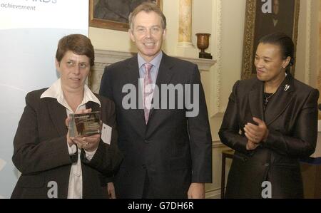 Il primo ministro Tony Blair e il ministro degli interni Baroness Scotland presentano lo scudo di giustizia a Carol Chilcott di Bristol, a Downing Street. Il remand Foster Care ha vinto non solo il premio generale, ma anche il contributo inestimato al lavoro con i trasgressori premio. I premi sono stati conferiti nel quadro dei premi di Giustizia, conferiti a persone in prima linea nel sistema giudiziario penale. Foto Stock